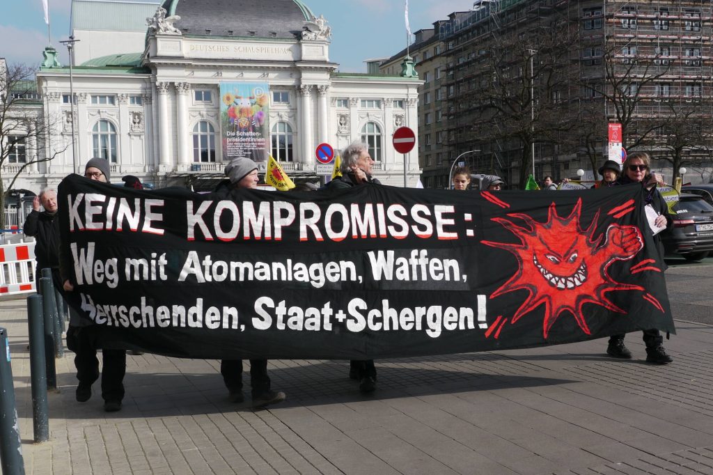 schwarzes großes Banner "Keine Kompro,isse. Weg mit Atomanlage, Waffen, Herrschenden, Staat+Schergen