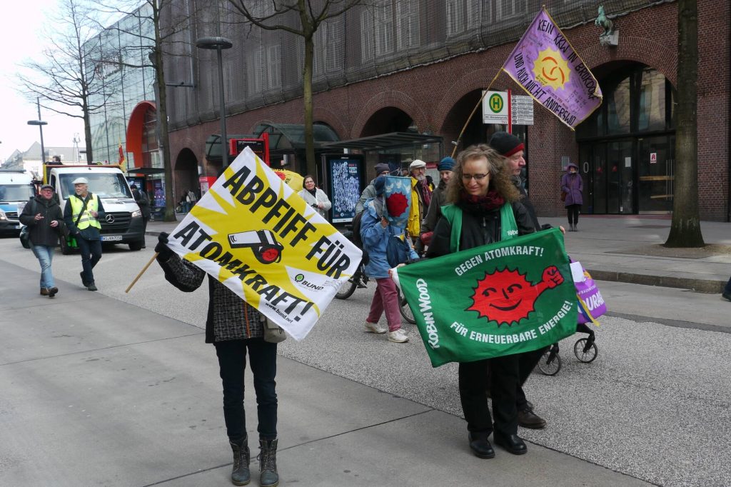 Menschen mit Fahenen " Abpfiff für Atomkraft und Gegen atomkraft für Eneruerbare Energie Robin Wood!